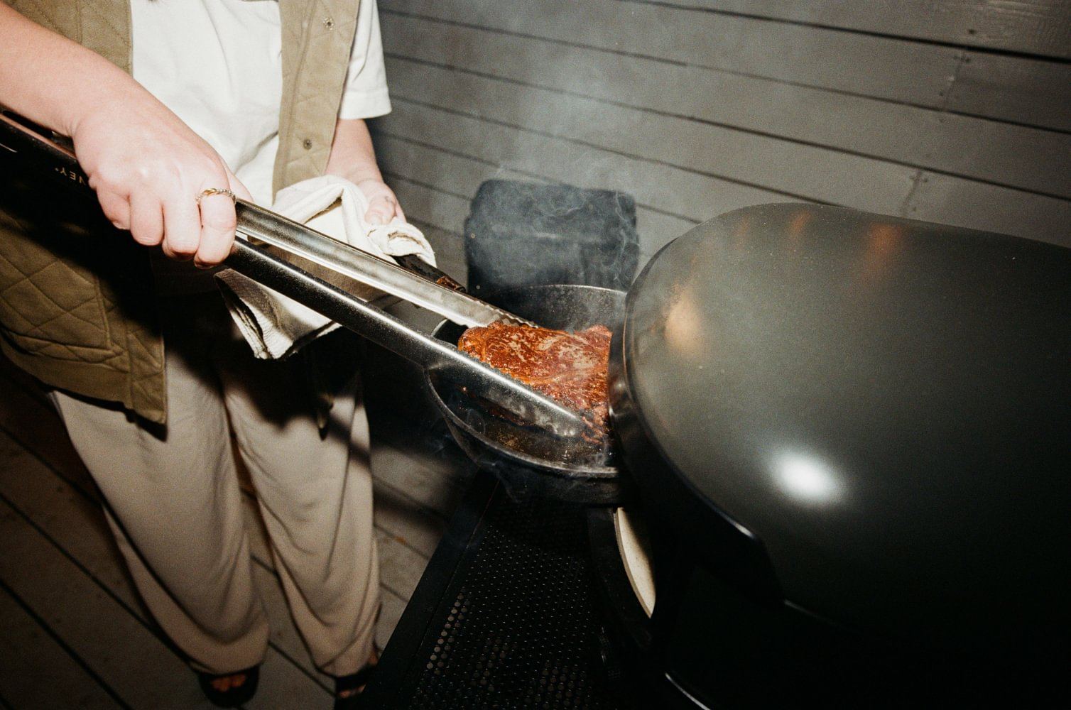 Close up of a premium orange ceramic kamado grill with smoke coming out, dramatic lighting